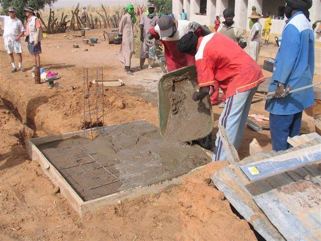 Maçons réalisant une borne fontaine