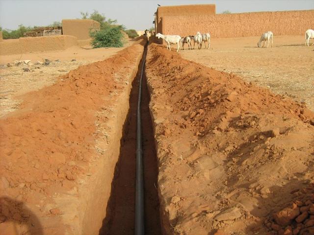 Les tuyaux en pvc viennent d'être déposés au fond de la tranchée.
